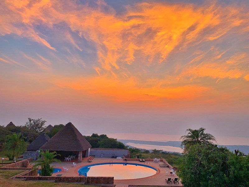 Fiery sunrise sky over hilltop lodge pool in Akagera, Rwanda