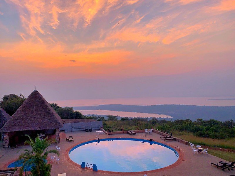 Hilltop pool overlooking lake at sunrise in Akagera, Rwanda