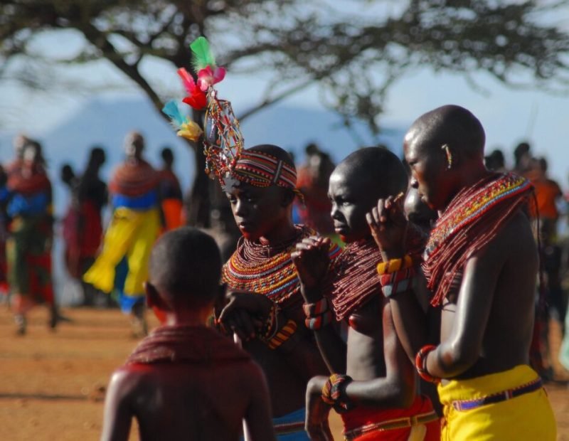 Warriors and women in beadwork at a village dance