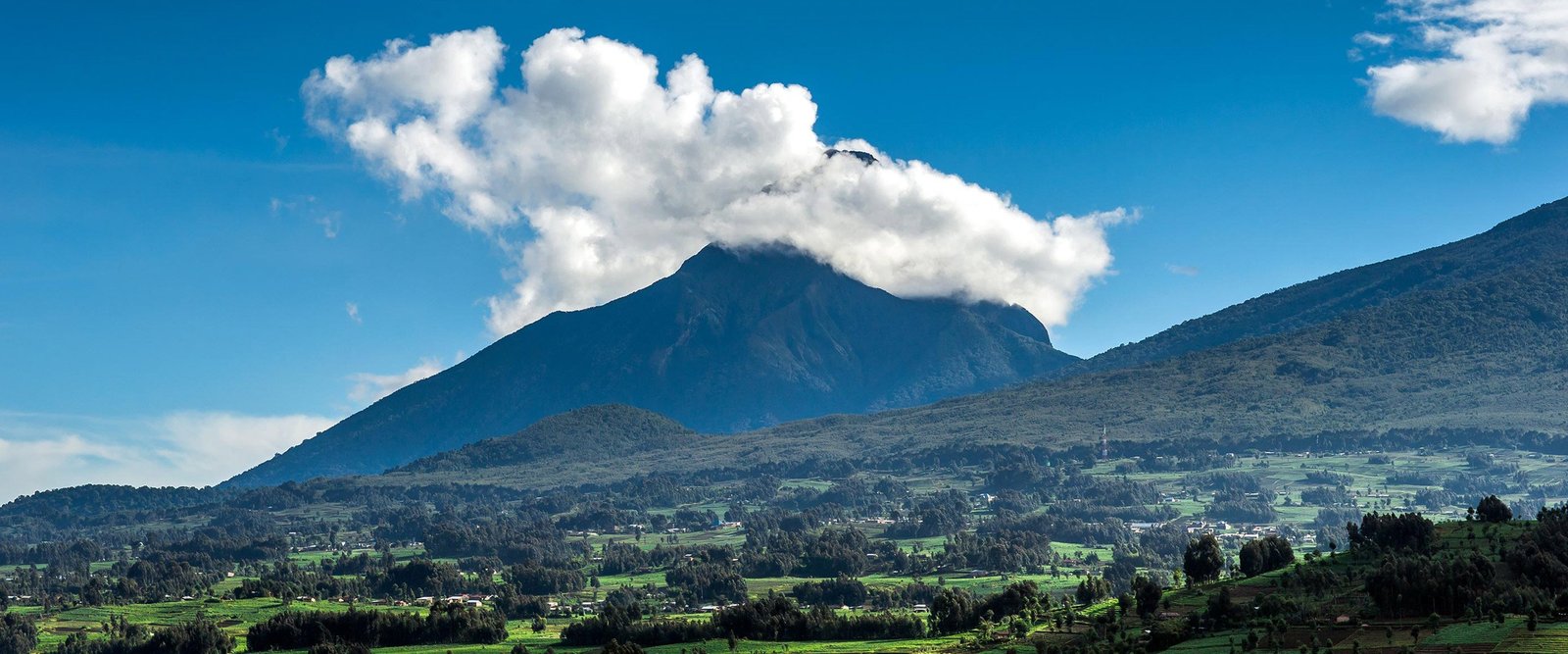 Panorama of volcano above green farmland in Volcanoes, Rwanda