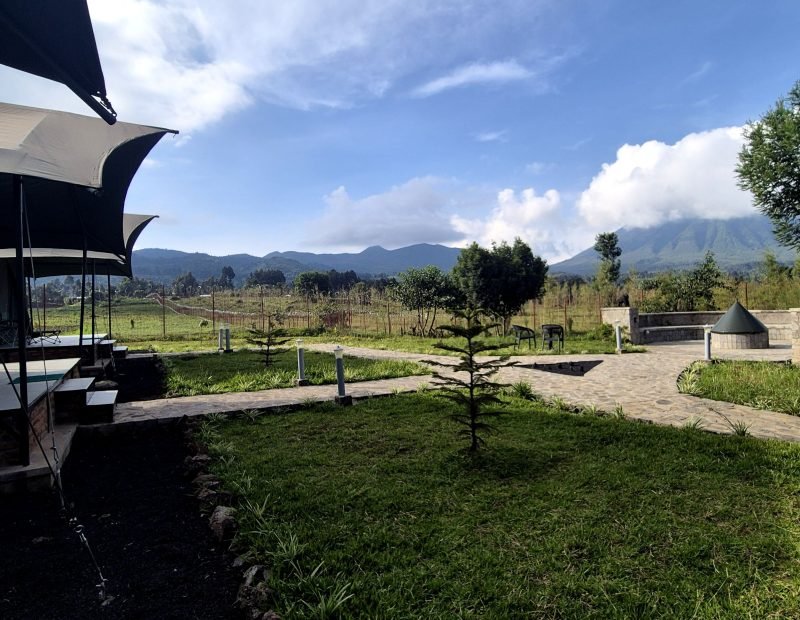 Tented camp lawn with volcano range view in Volcanoes, Rwanda